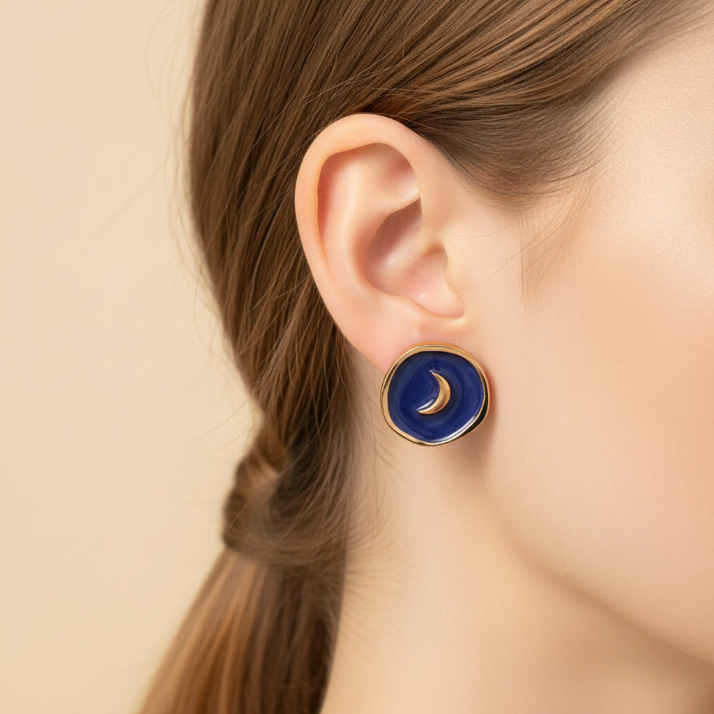 Luna Crescent Earrings worn on ear with cream background